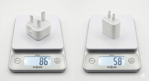 A digital kitchen scale showing a UK 3-pin charger at exactly 86g (or a US 2-pin at 58g).